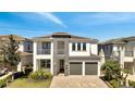 Modern two-story home with a stylish stone accent, a covered balcony, and a two-car garage at 7921 Jacks Club Dr, Kissimmee, FL 34747