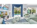 Bright living room with pool view through sliding glass doors and elegant blue accents at 8462 Secret Key Cv, Kissimmee, FL 34747
