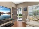 Cozy living room with an open front door, light-filled window, and comfortable seating arrangement at 8982 Shine Drive, Kissimmee, FL 34747