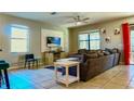 Relaxing living room area with a ceiling fan, large windows, and access to the outdoor pool at 9156 Wedge Dr, Davenport, FL 33896