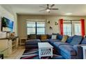 Spacious living room featuring a large sectional sofa, a ceiling fan, and backyard access at 9156 Wedge Dr, Davenport, FL 33896