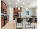 Modern kitchen with stainless steel appliances, island seating, and stylish pendant lights at 1264 Bonita Canyon Dr, Kissimmee, FL 34759