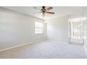 Bright bedroom with neutral carpeting, ceiling fan, and ample natural light at 1418 Delaware Ave, St Cloud, FL 34769