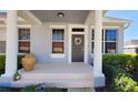 Charming front porch with decorative wreath and manicured landscaping creates an inviting entrance at 14620 Golden Rain Tree Blvd, Orlando, FL 32828