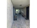 Well-lit hallway with stone flooring, ornate benches, and unit doors at 175N Pearl Lake Cswy # 114, Altamonte Springs, FL 32714