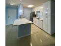 Open kitchen concept with breakfast bar, modern lighting, and sleek white cabinetry at 175N Pearl Lake Cswy # 114, Altamonte Springs, FL 32714