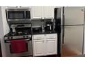 Kitchen with white cabinets and stainless steel appliances at 2019 Dixie Belle Dr # 2019L, Orlando, FL 32812