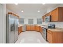 Spacious kitchen with stainless steel appliances, granite counters, and bright white tile flooring at 251 Tower View W Dr, Haines City, FL 33844
