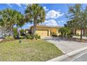 Charming home featuring lush landscaping, a paved driveway, and a two-car garage at 3390 Fallbrook Dr, Kissimmee, FL 34759