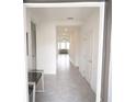 Bright hallway featuring neutral tile flooring, recessed lighting, and white doors at 4211 Little Owl Ln, Kissimmee, FL 34746