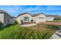 A cozy single-Gathering home with a tidy front lawn, blue window shutters, and an attached garage at 485 Disa Dr, Davenport, FL 33837