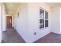 Covered entryway featuring brick pavers, leading to the home's front door and adjacent window at 4918 Drawdy Ct, St Cloud, FL 34772