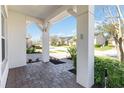 Covered front porch with brick pavers offering a glimpse of the landscaped community at 4918 Drawdy Ct, St Cloud, FL 34772