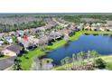 Picturesque aerial view of homes backing up to a tranquil pond, surrounded by lush greenery and natural beauty at 555 Presido Park Pl, Kissimmee, FL 34759