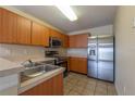 Well-lit kitchen featuring stainless steel appliances, wood cabinets, and a stainless sink at 635 Lake Marion Golf Resort, Kissimmee, FL 34759