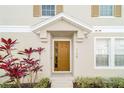 Inviting front entrance featuring a stylish door with sidelight, enhanced by colorful plants and modern house numbers at 7128 Red Lantern Dr # 0, Harmony, FL 34773