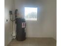 Practical utility area showcasing a modern water heater and durable tiled floor at 736 Nw 31St Ct, Winter Haven, FL 33881