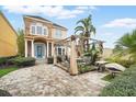 Beautiful home with a brick driveway and outdoor seating area with pergola at 7623 Excitement Dr, Reunion, FL 34747