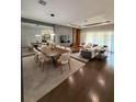 Modern living room with a dining area, hardwood floors, large mirror accent wall, and stylish contemporary decor at 8289 Topsail Pl, Winter Garden, FL 34787
