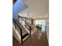 Modern living room with sleek hardwood floors, dining area, contemporary staircase and plenty of natural light at 8289 Topsail Pl, Winter Garden, FL 34787