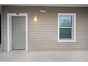 Apartment entrance featuring a well-lit doorway, a unit number, and a window with privacy blinds at 841 Retreat Blvd # 101, Davenport, FL 33897