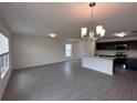 Bright open living space with modern gray floors, a stylish chandelier, and a view of the kitchen at 9081 Oscraft Dr, Davenport, FL 33896