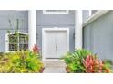 Inviting entryway with double doors and lush landscaping at 943 Van Loon Ct, Kissimmee, FL 34758