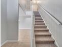 Carpeted staircase with white railing, leading to the upper level at 943 Van Loon Ct, Kissimmee, FL 34758