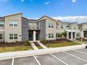 Modern townhomes with gray stone accents, landscaped front yards, and ample parking at 1048 Leader St, Davenport, FL 33896