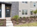 Close up of a modern townhome entrance with stone accents and landscaping at 1048 Leader St, Davenport, FL 33896