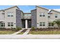 Well-maintained townhome with stone accents, contemporary design, and landscaped front yard at 1048 Leader St, Davenport, FL 33896