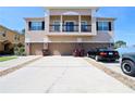 Exterior shot showing three-story townhome with garages, driveway, and second story balcony at 2120 Betsy Ross Ln, St Cloud, FL 34769