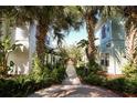Landscaped walkway through townhome community lined with palm trees and lush foliage creates a tranquil and inviting atmosphere at 2962 Lucayan Harbour Cir # 102, Kissimmee, FL 34746