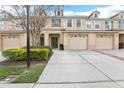 Townhome featuring attached garages, lush landscaping, and a welcoming front entrance at 3008 Thornton Dr, Kissimmee, FL 34741