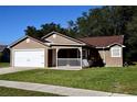 Inviting single-Gathering house with a manicured lawn, front porch, and an attached garage at 4235 W Vista Ct, Kissimmee, FL 34746