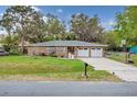 Charming brick home featuring a well-maintained lawn, double garage, and inviting facade at 4884 Meadow Dr, St Cloud, FL 34772