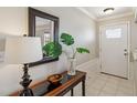 Inviting foyer features a console table, decorative mirror, and tiled flooring at 534 Minnow Ct, Kenansville, FL 34739