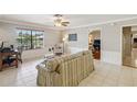 Bright living room with tile floors, crown molding, and a view of the backyard at 534 Minnow Ct, Kenansville, FL 34739