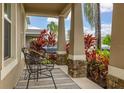 Cozy front porch featuring decorative columns, stone accents, and stylish outdoor seating at 5685 Surprise Lily Dr, Winter Garden, FL 34787