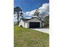 Single-story home featuring a two-car garage, concrete driveway, and landscaped lawn at 6 Bahia Course Ln, Ocala, FL 34472
