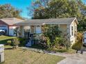 View of the single-story home with cozy porch, plants, and well-maintained lawn at 615 N Emory Ave, Kissimmee, FL 34741
