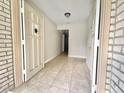 View of the bright entryway features neutral tile flooring, a white front door, and access to other rooms at 616 N Palm Ave, Kissimmee, FL 34741