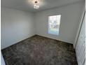 Bright bedroom with plush carpet, a window with blinds, and a decorative ceiling light at 676 Tanaro Ln, Haines City, FL 33844