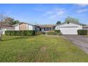 Single-story home features a brick accent, large front lawn and an attached two car garage at 706 Francis St, Kissimmee, FL 34741