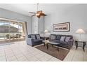 Bright living room with tile flooring, ceiling fan, and sliding glass doors to the pool area at 8063 King Palm Cir, Kissimmee, FL 34747