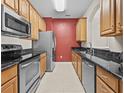 Well-lit kitchen with stainless steel appliances, wood cabinets, and granite countertops at 8300 Portofino Dr # 403, Davenport, FL 33896