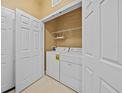 Laundry closet with white washer and dryer, as well as shelving for storage at 8300 Portofino Dr # 403, Davenport, FL 33896