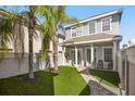 Inviting backyard with lush artificial turf, landscaping and a paved walkway leading to the house at 861 Golden Bear Dr, Reunion, FL 34747