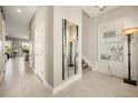 Inviting hallway with tile flooring, neutral paint, and stylish lighting fixtures leading to other living spaces at 861 Golden Bear Dr, Reunion, FL 34747