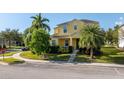Two-story yellow home with landscaping and palm trees at 1000 Seburn Rd, Apopka, FL 32703